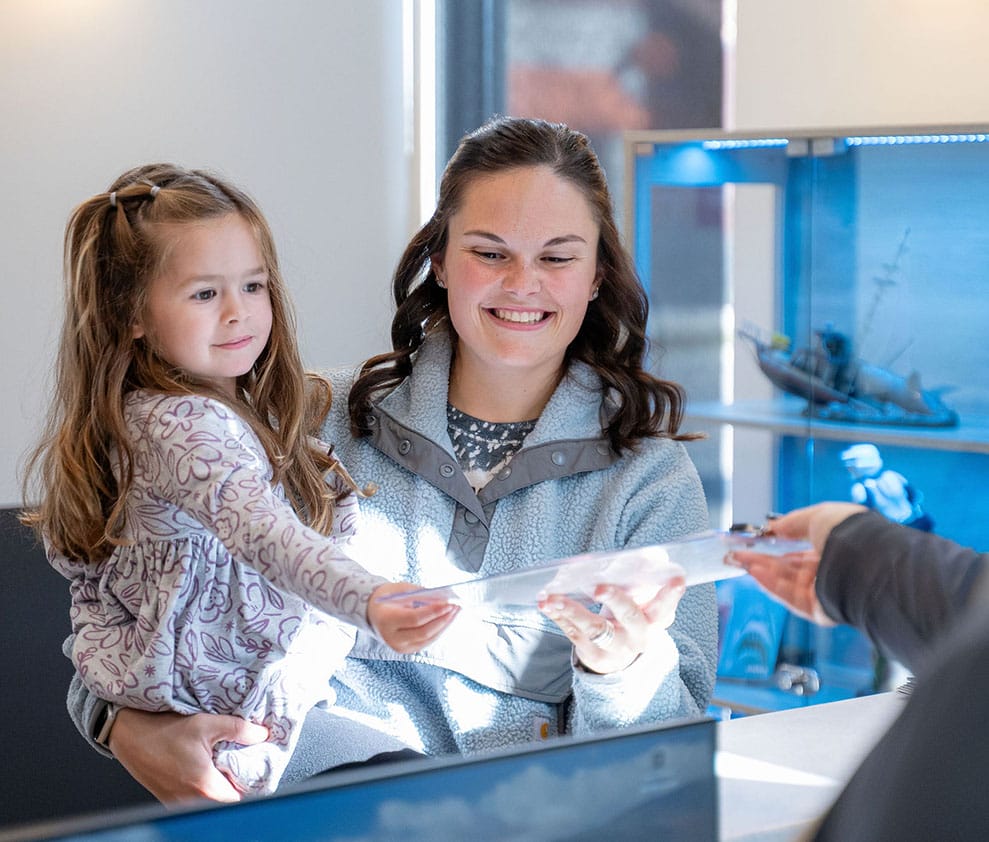 Dr. Sortino at Canal Kids Dentistry smiling and interacting with a young patient before a tongue-tie procedure.