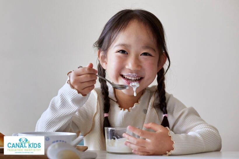 Young girl eating yogurt during recovery after oral dental sedation